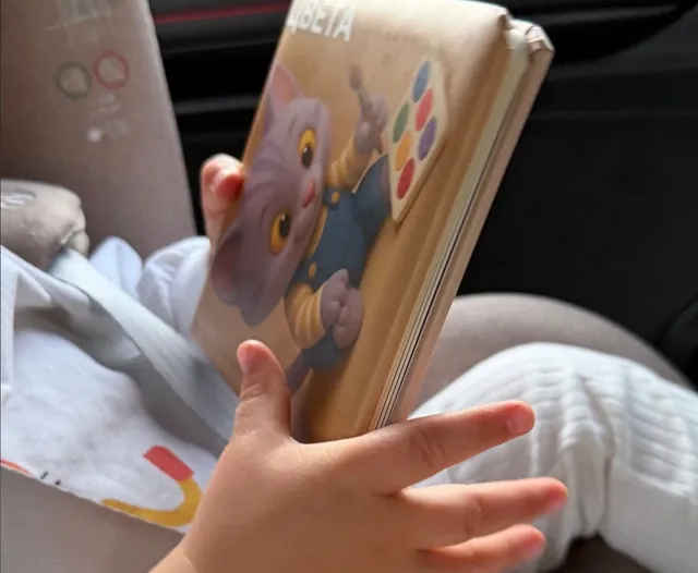 Малыш листает книжку «Цвета» в автокресле