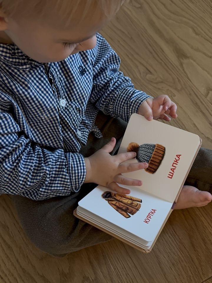 Малыш показывает шапку в книжке «Одежда»